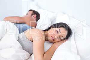 Upset couple lying on bed