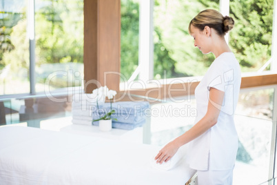 Female masseur rolling towel