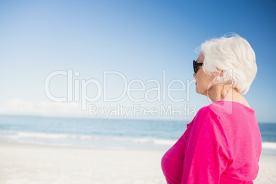 Happy senior woman with sunglasses looking at water