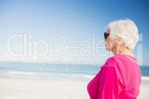 Happy senior woman with sunglasses looking at water