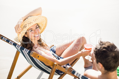 Young couple sitting on armchair with cocktail drink