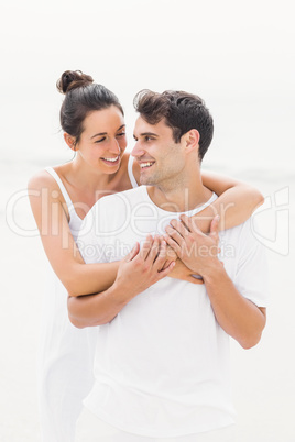 Happy couple embracing each other on the beach