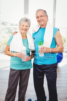 Portrait of smiling senior couple holding bottle