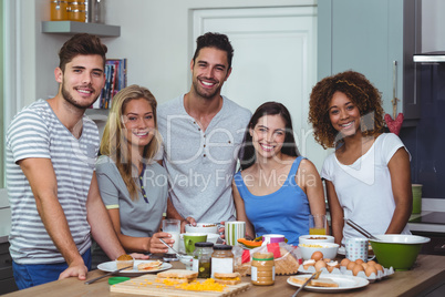 Cheerful young friends standing at table