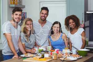 Cheerful young friends standing at table