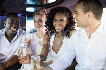 Well dressed people drinking champagne in a limousine