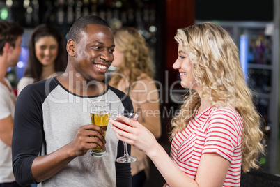 Friends toasting with cocktail and beer