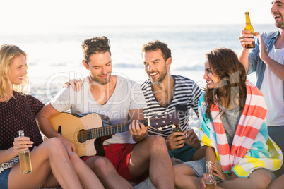 Friends drinking beer and playing guitar