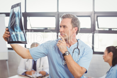 Doctor examining an x-ray report in conference room