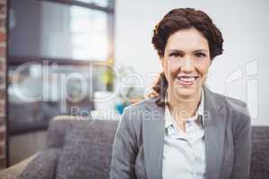 Happy young businesswoman sitting on sofa