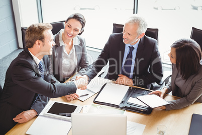 Businessmen shaking hands in conference room