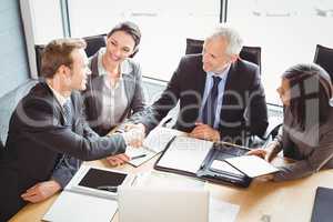 Businessmen shaking hands in conference room