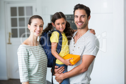 Portrait of happy family with daughter holding lunch box