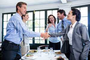 Business colleagues shaking hands after a successful lunch meeti