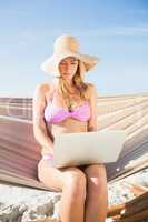 Woman using her laptop in hammock