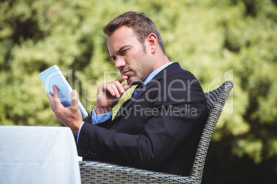 Thoughtful businessman using tablet