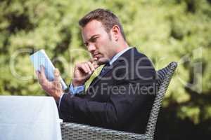 Thoughtful businessman using tablet