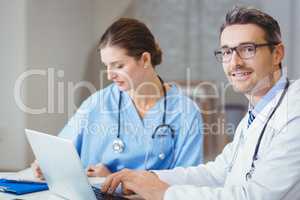 Portrait of smiling male doctor sitting at desk
