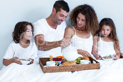 Family having breakfast in bed