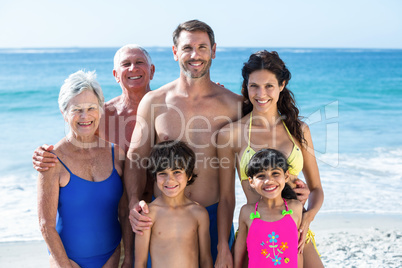 Cute multi generation family posing on the beach