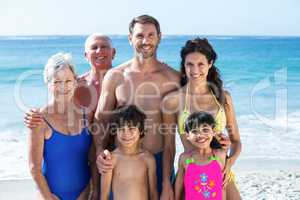 Cute multi generation family posing on the beach