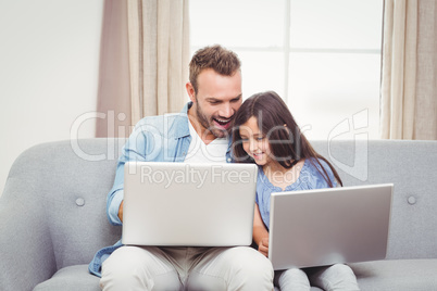 Father and daughter using laptop