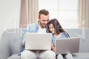 Father and daughter using laptop