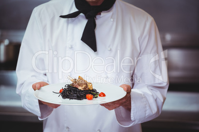 Chef holding a dish with spaghetti