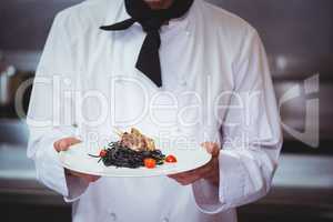Chef holding a dish with spaghetti