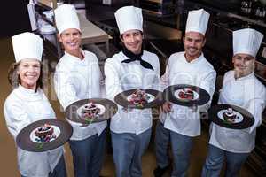 Happy chefs presenting their dessert plates
