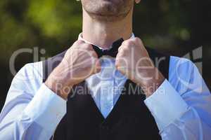Handsome waiter reattaching his bow tie