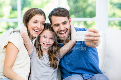 Laughing family clicking selfie with smartphone
