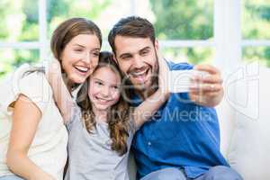 Laughing family clicking selfie with smartphone