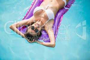 Happy young woman relaxing on inflatable raft