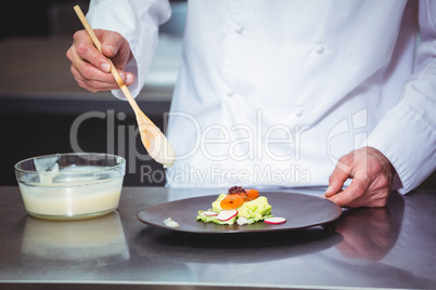 Chef putting chocolate sauce on a dessert