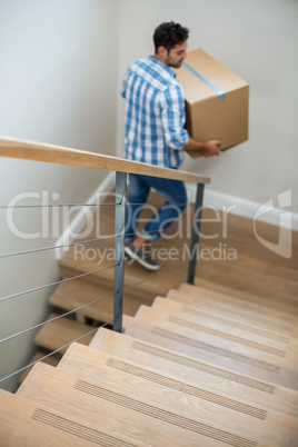 High angle view of man holding cardboard box while walking on st