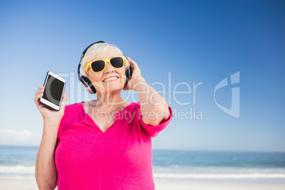 Senior woman listening music with headphone