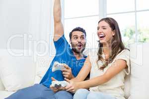 Couple enjoying video game on sofa