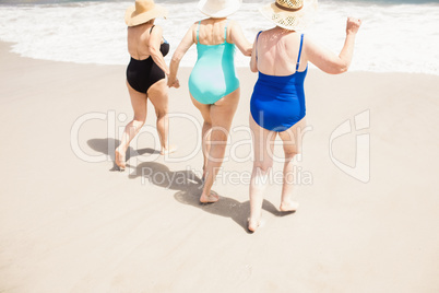 Senior woman friends running into water