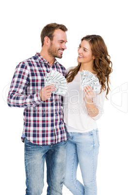 Happy young couple holding fanned out currency notes