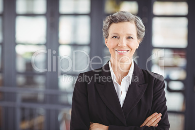 Confident businesswoman with arms crossed in office