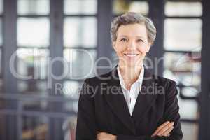 Confident businesswoman with arms crossed in office