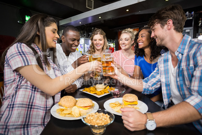 Happy friends having a drink and hamburger