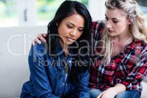 Young woman consoling depressed female friend