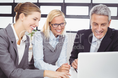 Business people looking in laptop during meeting