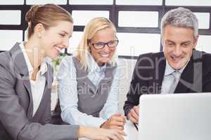 Business people looking in laptop during meeting