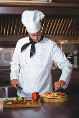 Chef slicing vegetables to put on a pizza