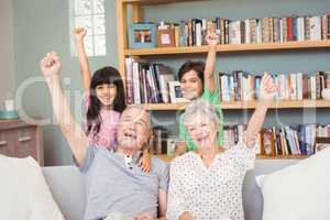 Grandchildren with grandparents gesturing success sign