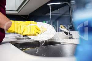 Cropped hand of woman washing plate