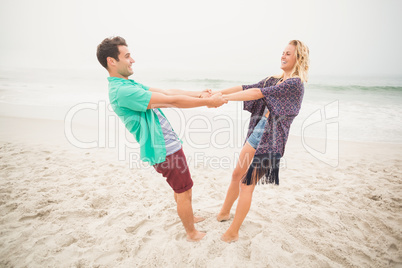 Happy couple holding hands on the beach
